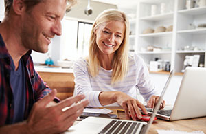 Couple smiling and looking at laptop